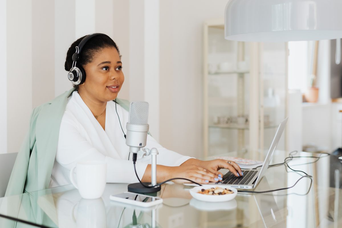 A creator preparing content at a laptop and microphone